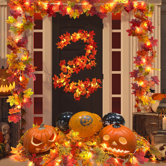 Decorative setup with pumpkins, balloons, and autumn leaves for Halloween.