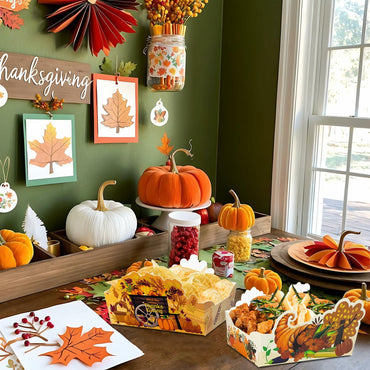 Thanksgiving-themed table setting with pumpkins, cornucopia, and autumn decorations.