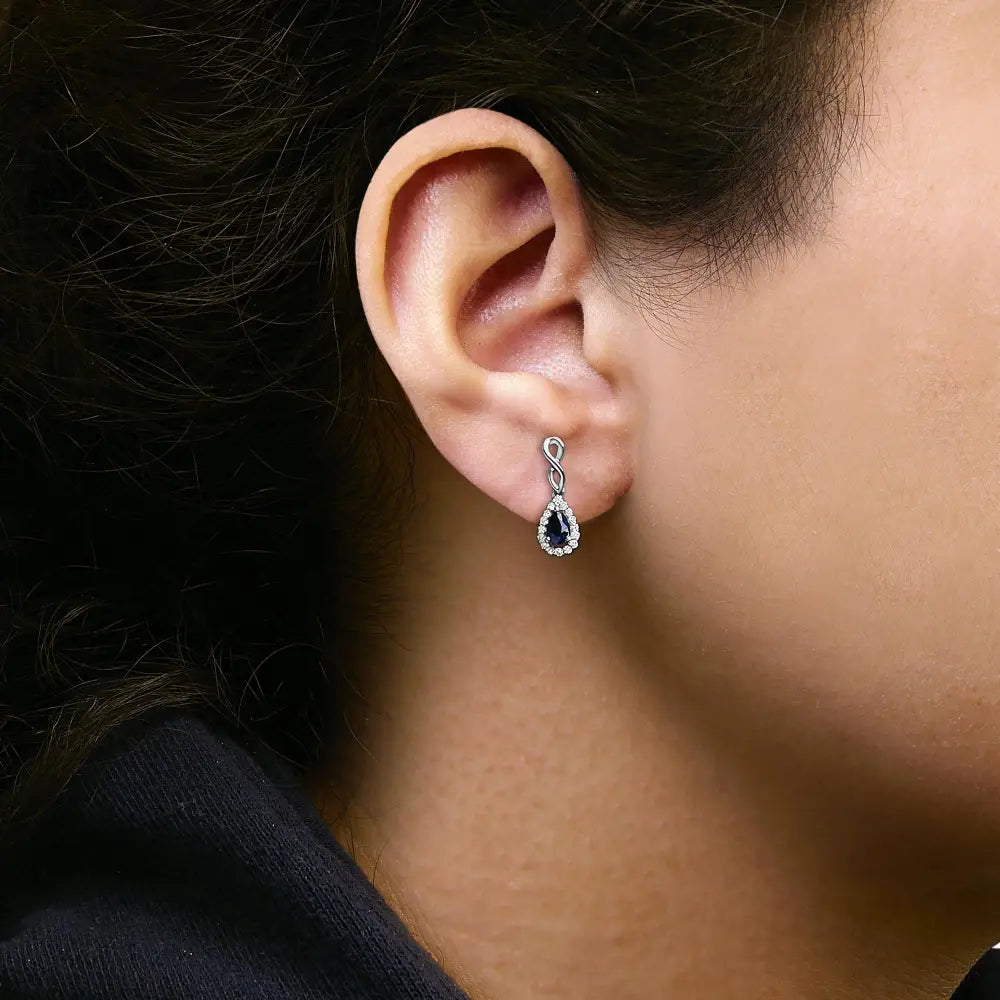 Blue Sapphire and 1/7 CTTW Diamond Infinity Drop Earrings in 10K White Gold