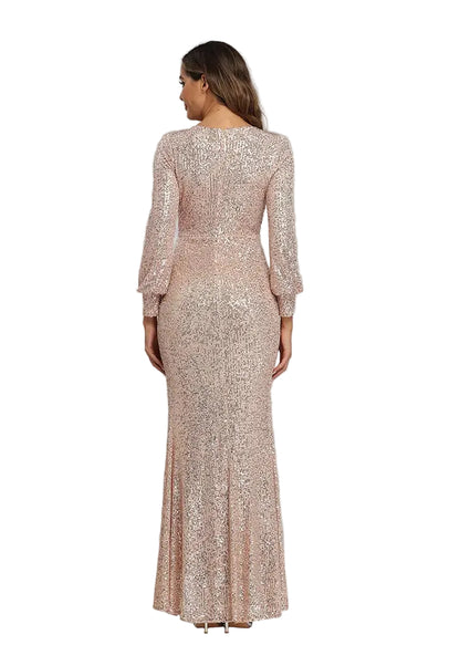 A woman viewed from the back wearing a floor-length, long-sleeve evening gown covered in shimmering blush pink sequins against a plain light gray studio background.