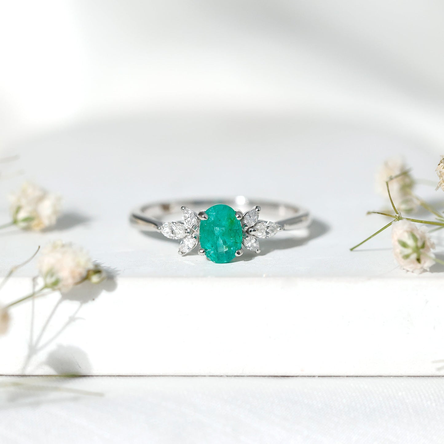 Oval Shaped Emerald Engagement Ring with Marquise Diamond Trio