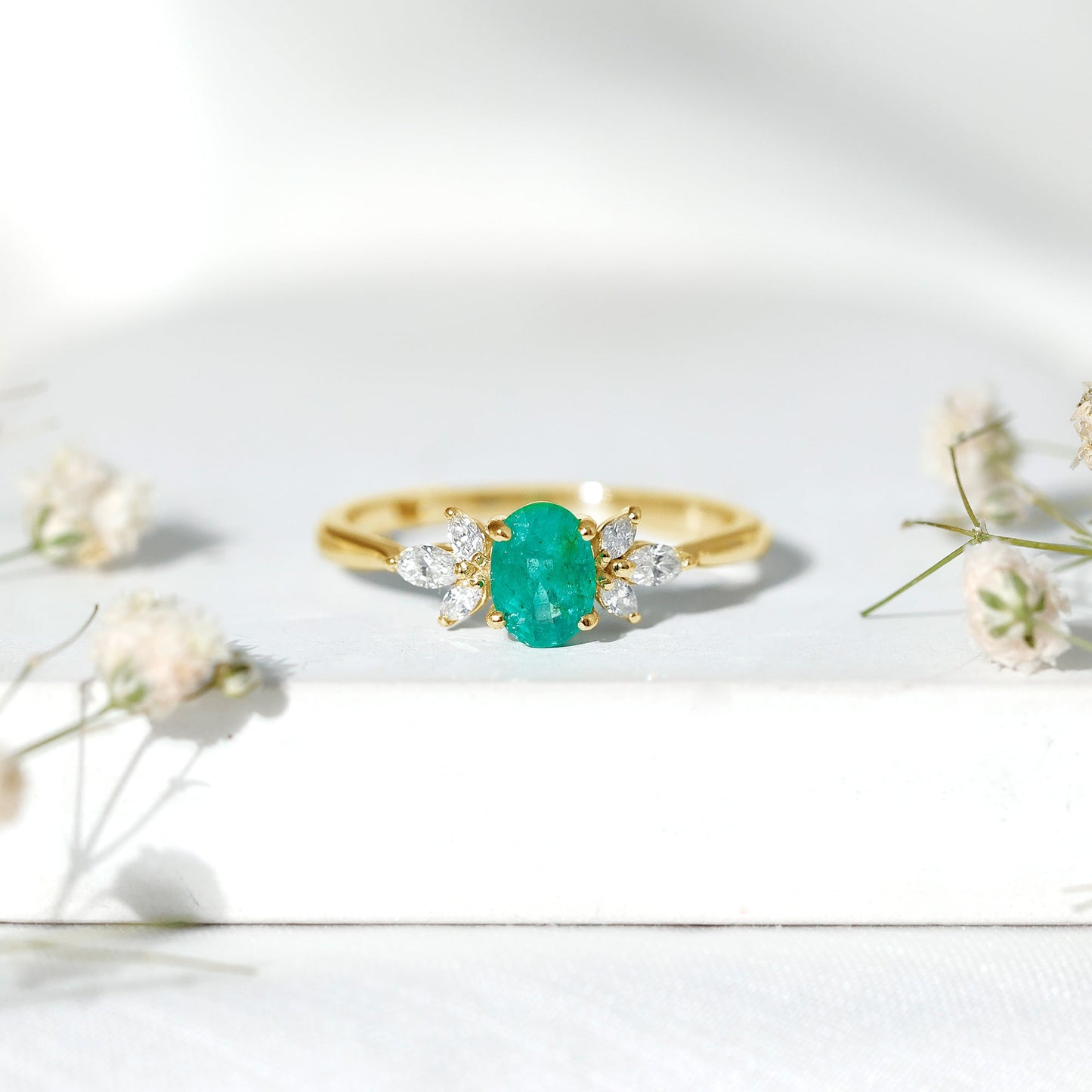 Oval Shaped Emerald Engagement Ring with Marquise Diamond Trio