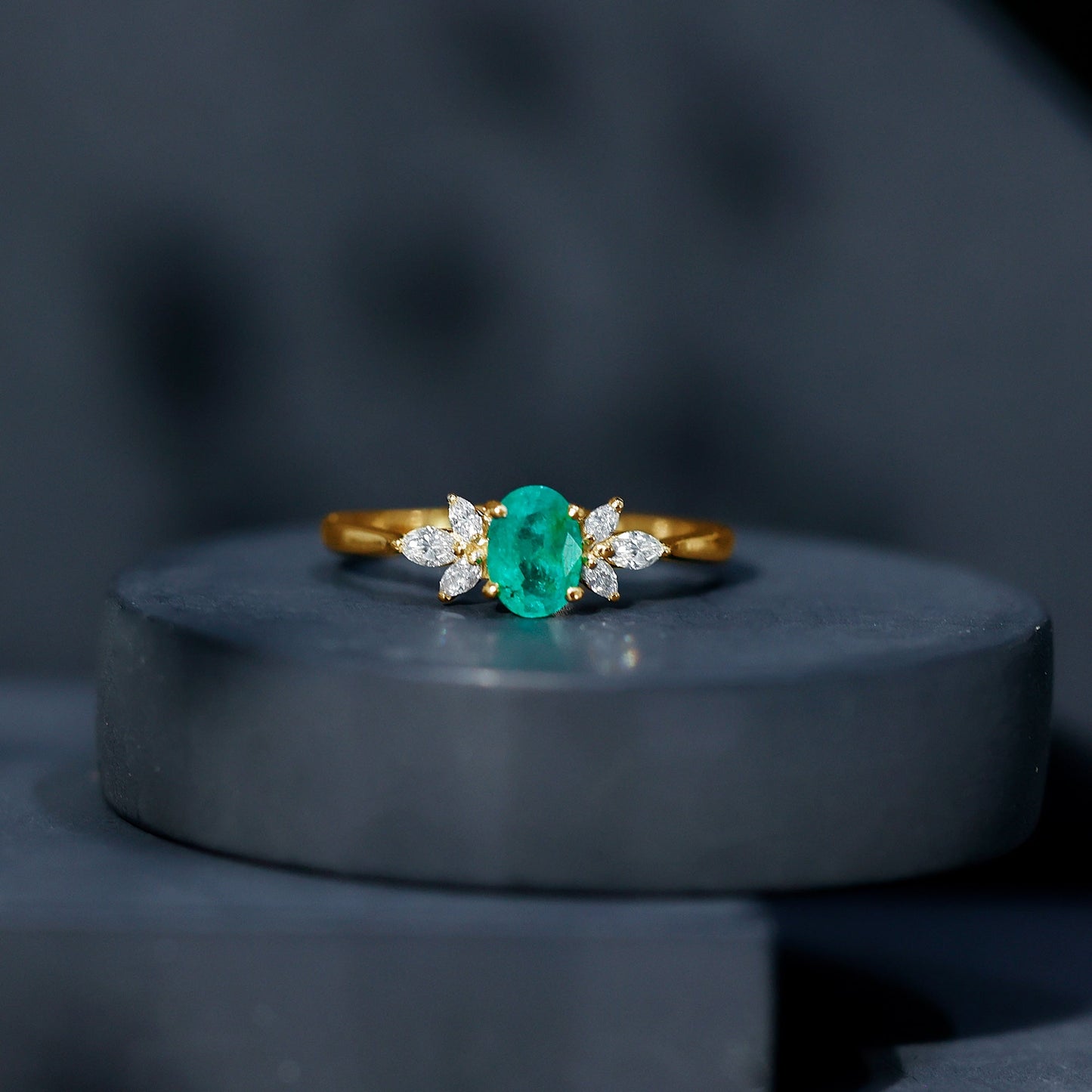 Oval Shaped Emerald Engagement Ring with Marquise Diamond Trio