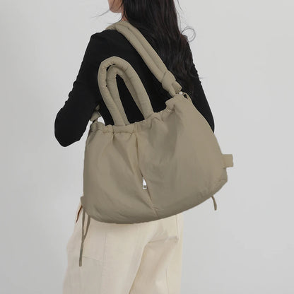 Person wearing a beige backpack against a plain background