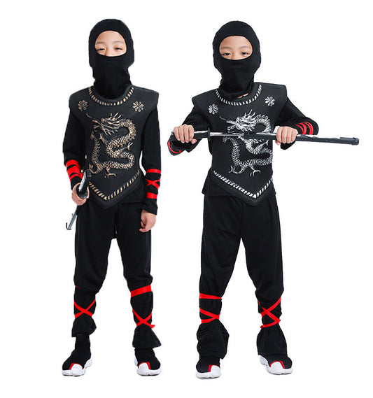 Two children in black ninja costumes with dragon designs, holding  