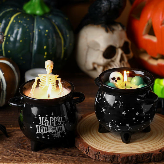 Halloween-themed candles with skeleton and skull designs in black cauldron holders.