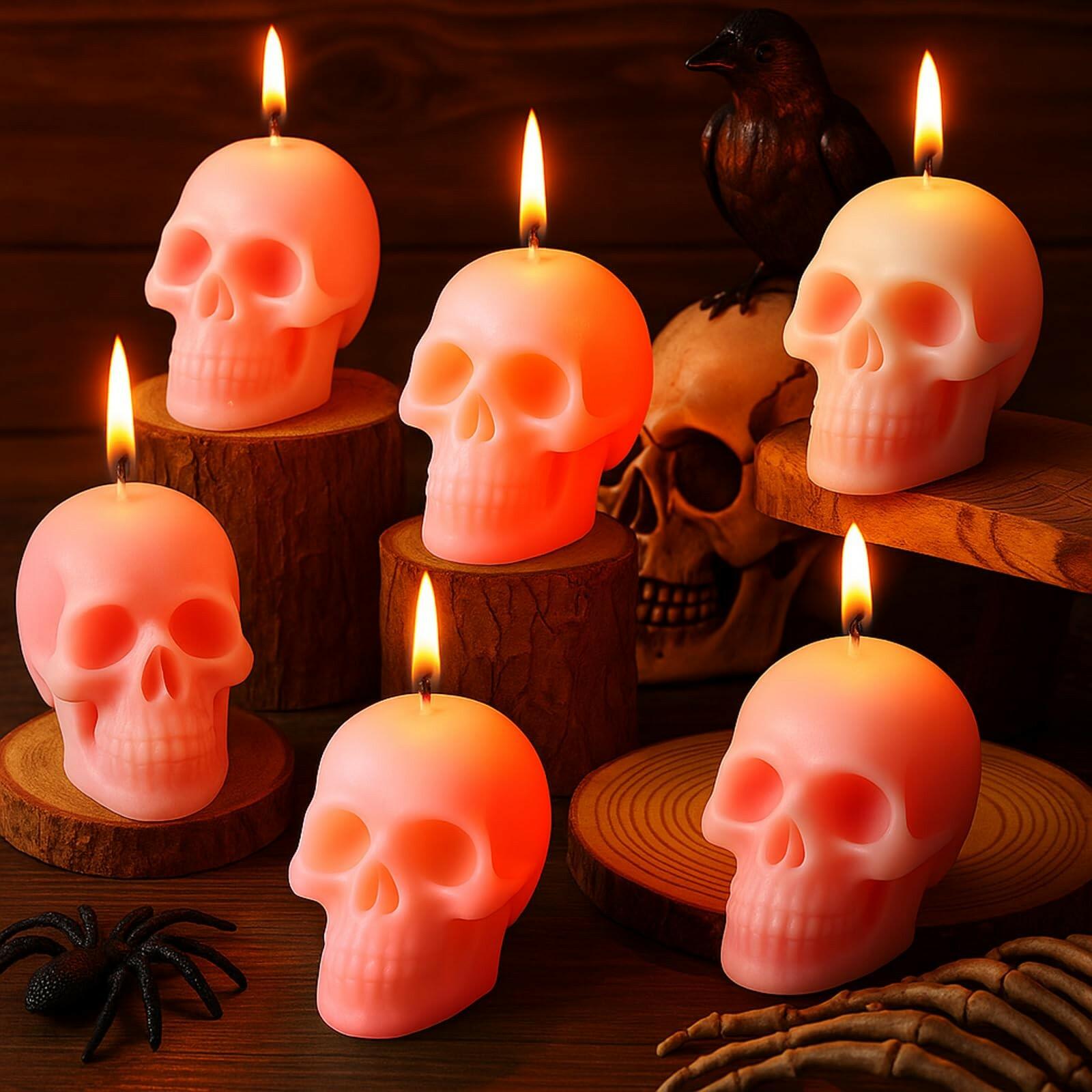 Skull-shaped candles with a warm glow on a wooden surface with decorative elements.